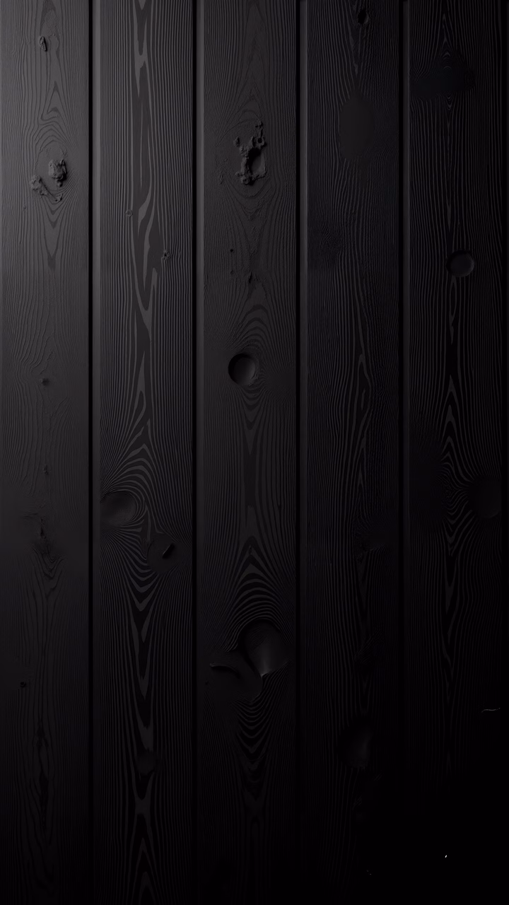 Dark wood texture with intricate grain patterns and knots in a monochromatic black palette.