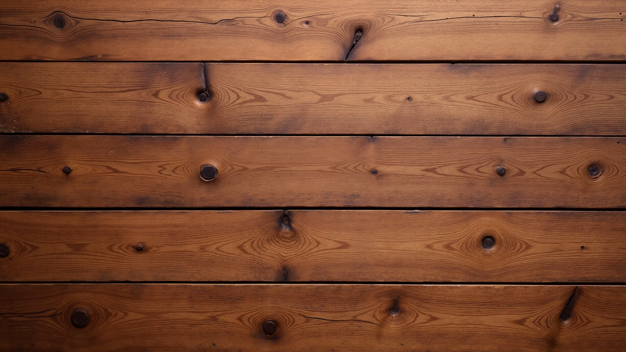 Close-up of wooden planks with natural grain patterns and knots, showcasing rustic charm.