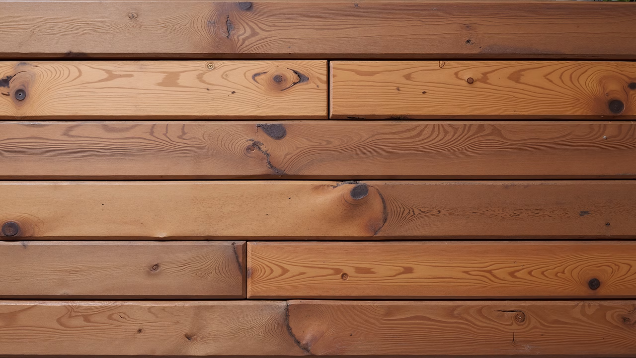 Close-up of wooden planks with natural grain patterns and warm tones.
