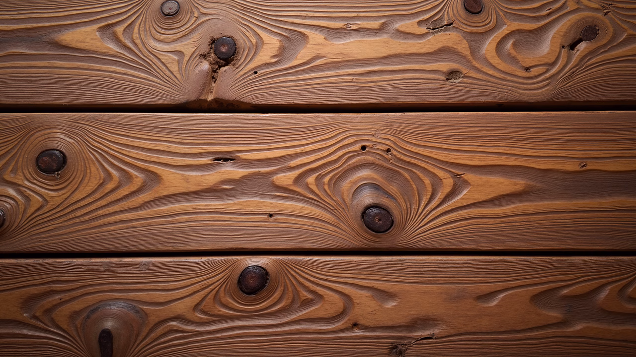 Close-up of wooden planks with detailed grain patterns and warm brown tones.