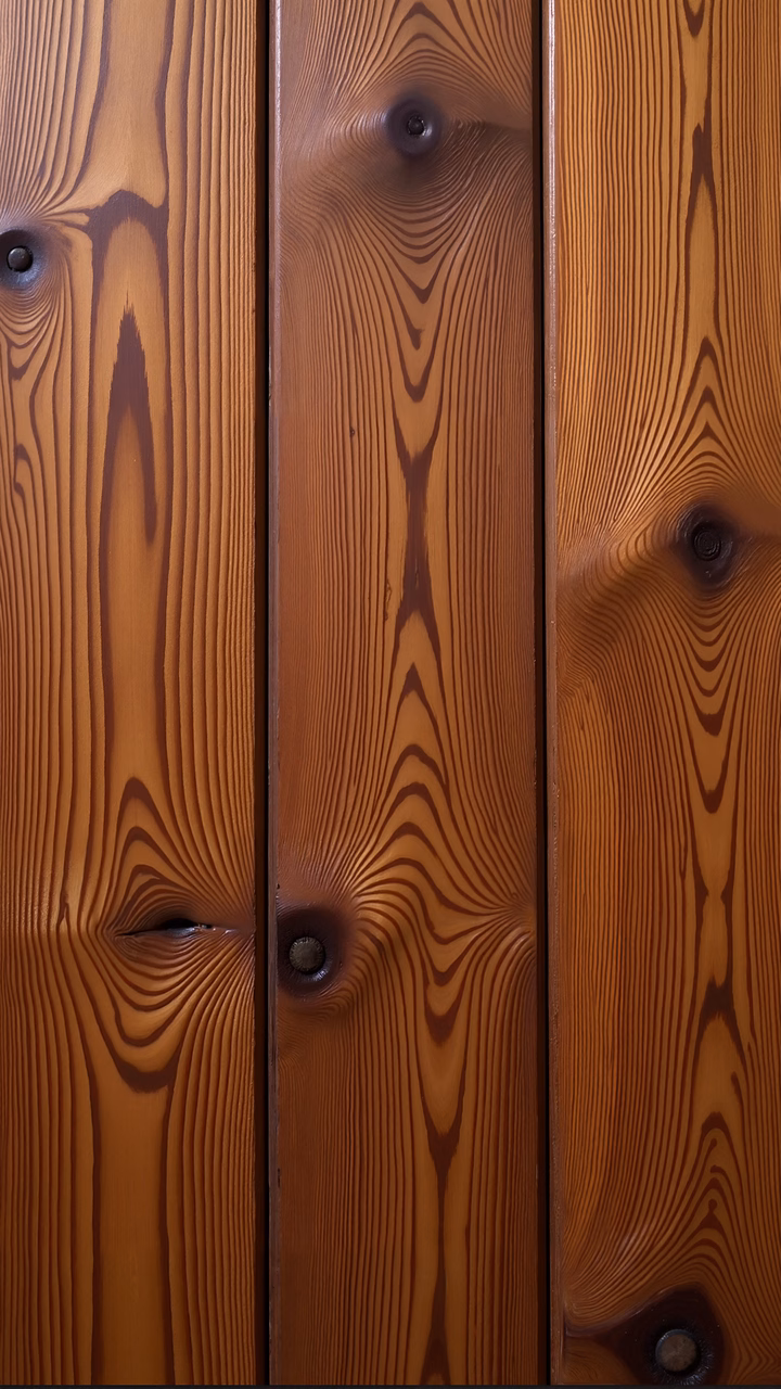 Close-up of wooden planks with detailed grain patterns and knots, evoking warmth and rustic charm.