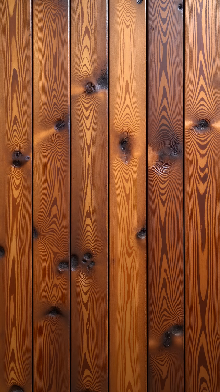 Close-up of wooden planks showcasing natural grain and knots in warm tones.