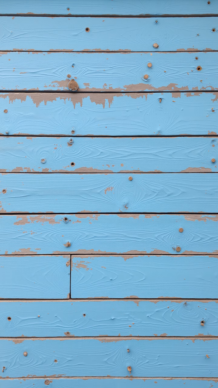 Close-up of weathered blue planks with natural grain and faded paint, evoking nostalgia.