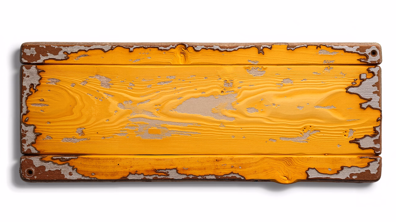 Close-up of weathered wooden planks with rich yellow hues and chipped paint.