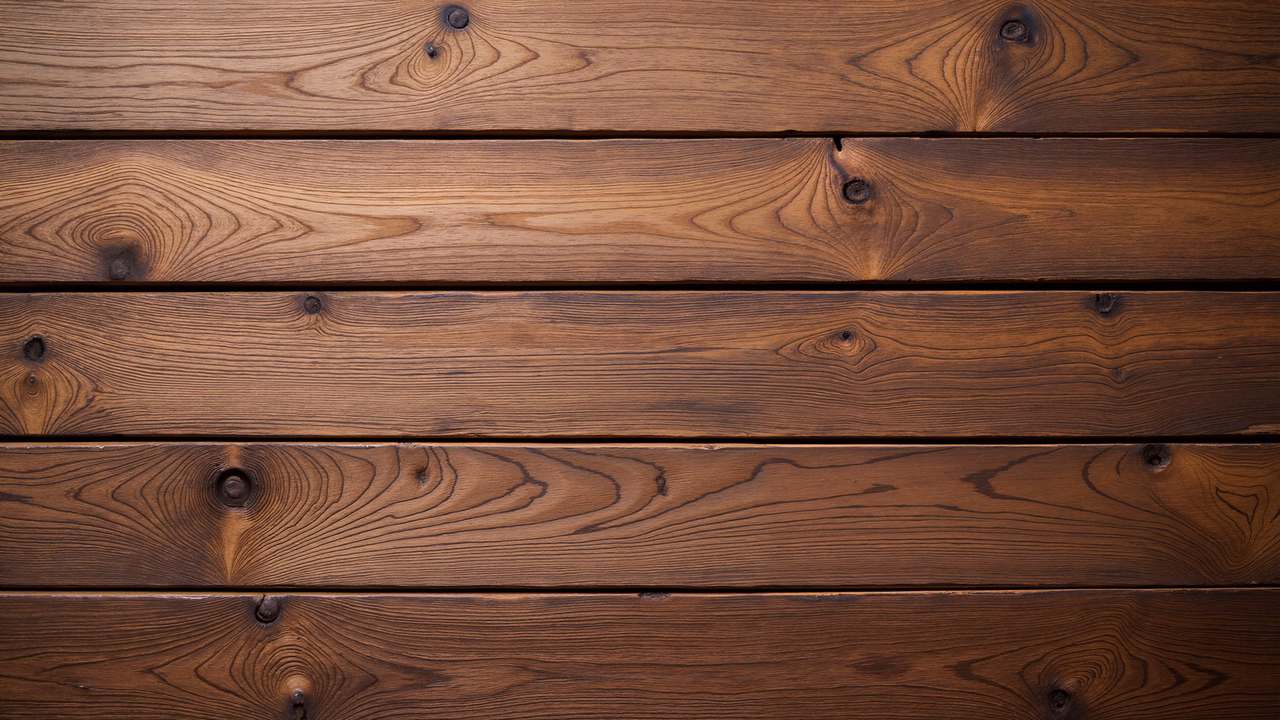 Close-up of wooden planks with natural grain and knots in warm brown tones.