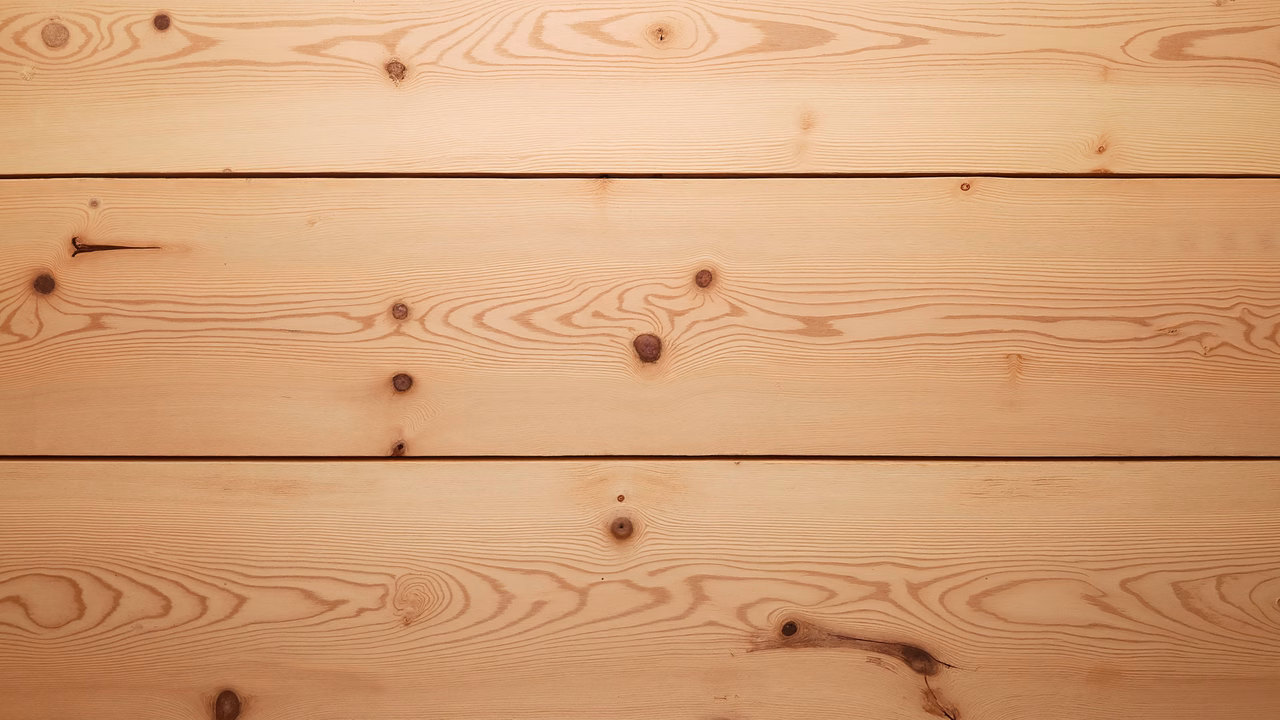 Close-up of wooden planks with natural grain patterns and knots, showcasing rustic charm.