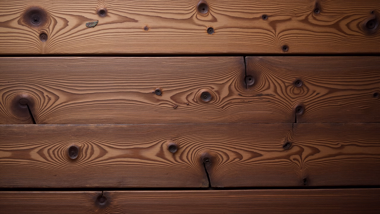 Close-up of wooden planks with intricate grain patterns and knots, highlighting natural beauty and craftsmanship.