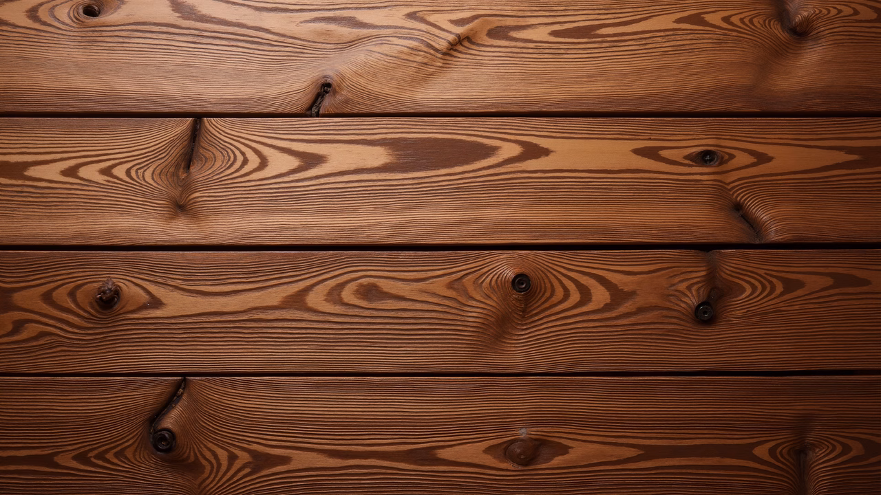 Close-up of wooden planks with natural grain patterns and knots, evoking rustic charm.