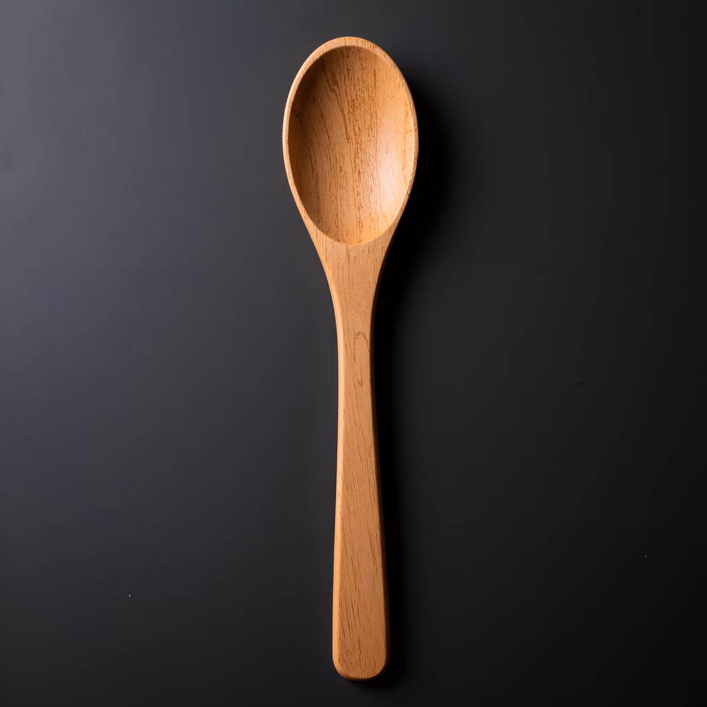 Simple wooden spoon on a black background, emphasizing natural grain and warmth.