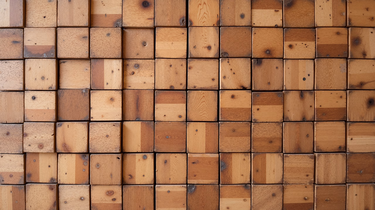 Uniform wooden squares arranged in a grid, showcasing natural grain patterns and varying shades of brown.