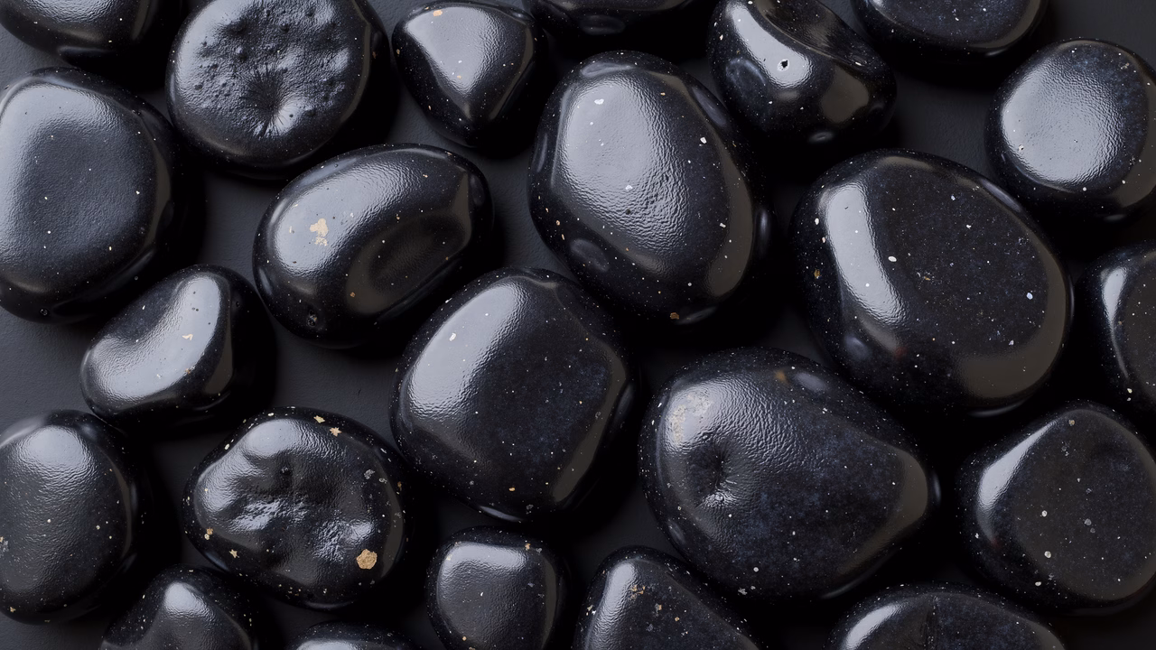 Close-up of glossy black pebbles, nature's intricate textures and shapes.