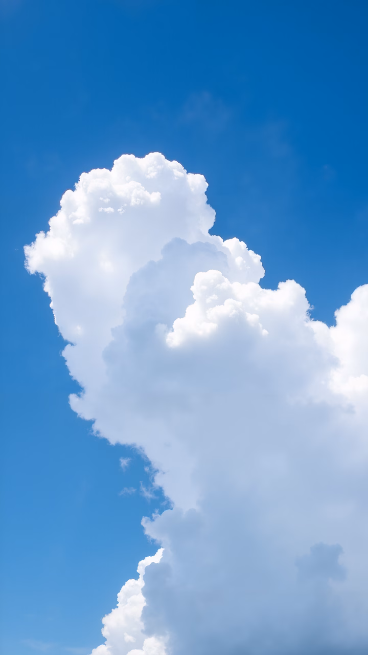 Vibrant blue sky with fluffy white clouds, evoking tranquility and natural beauty.