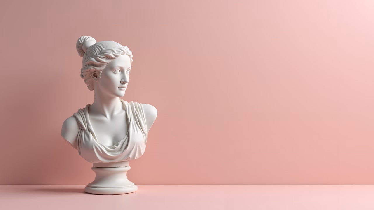 Elegant classical bust sculpture with serene female figure and soft pink background.