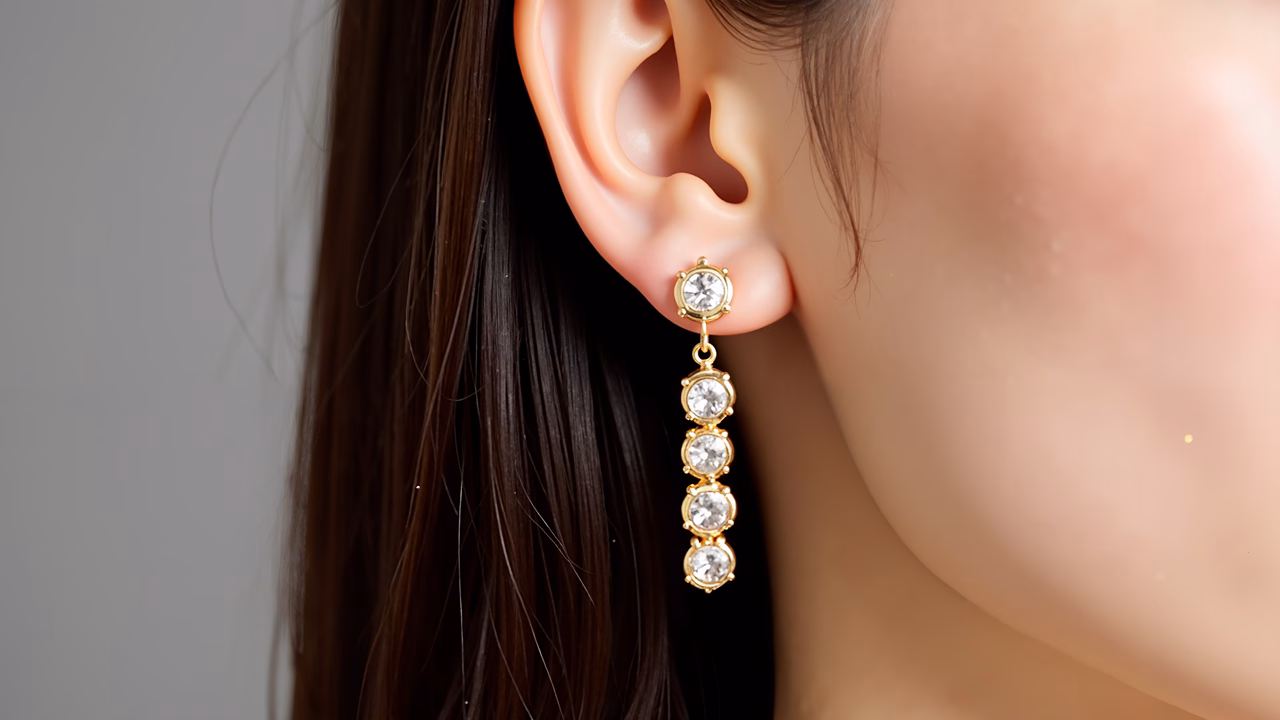Close-up of elegant crystal earrings with soft lighting and smooth skin tones.