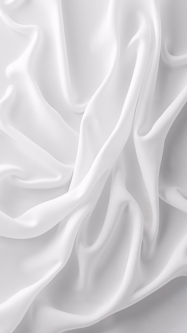 Close-up of silky white fabric with smooth textures and subtle variations in light and shadow.