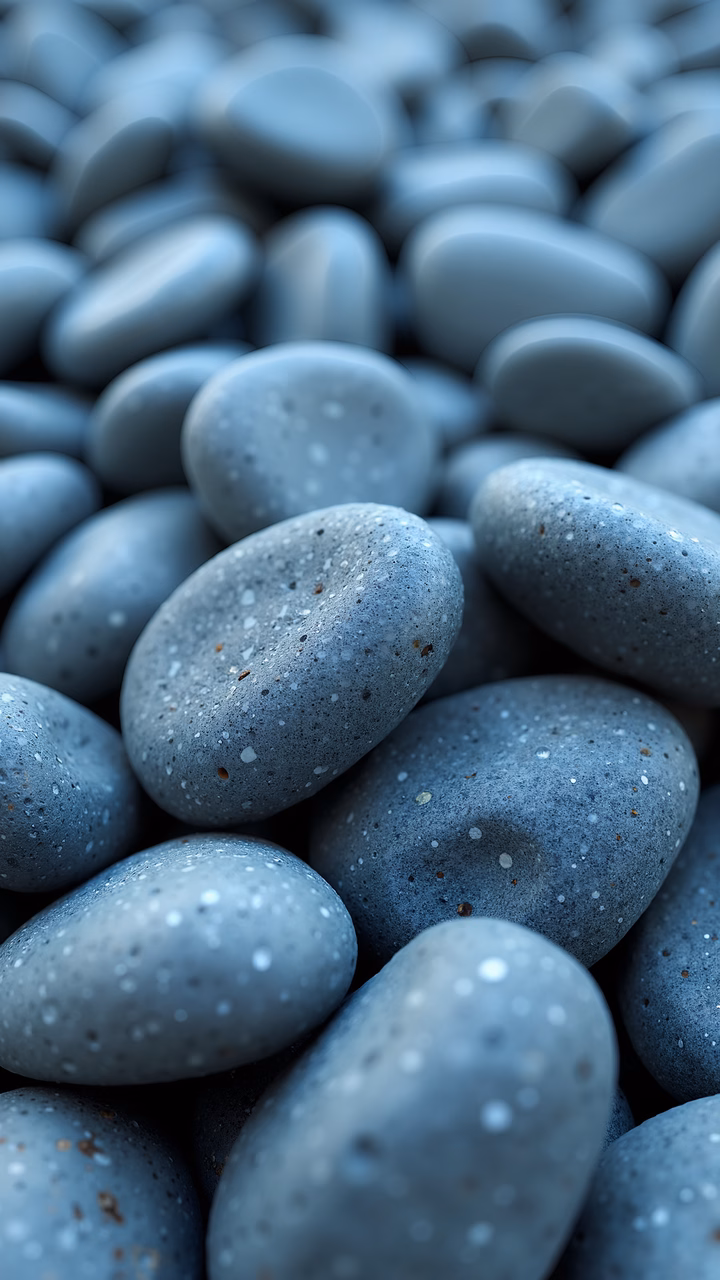 Close-up of smooth, speckled pebbles in shades of blue, creating a tranquil and natural scene.
