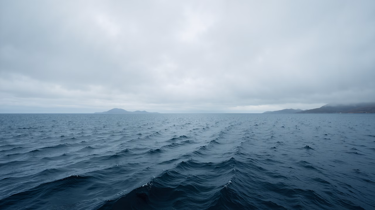 Dark ocean waves under a cloudy sky, evoking a sense of tranquility and vastness.